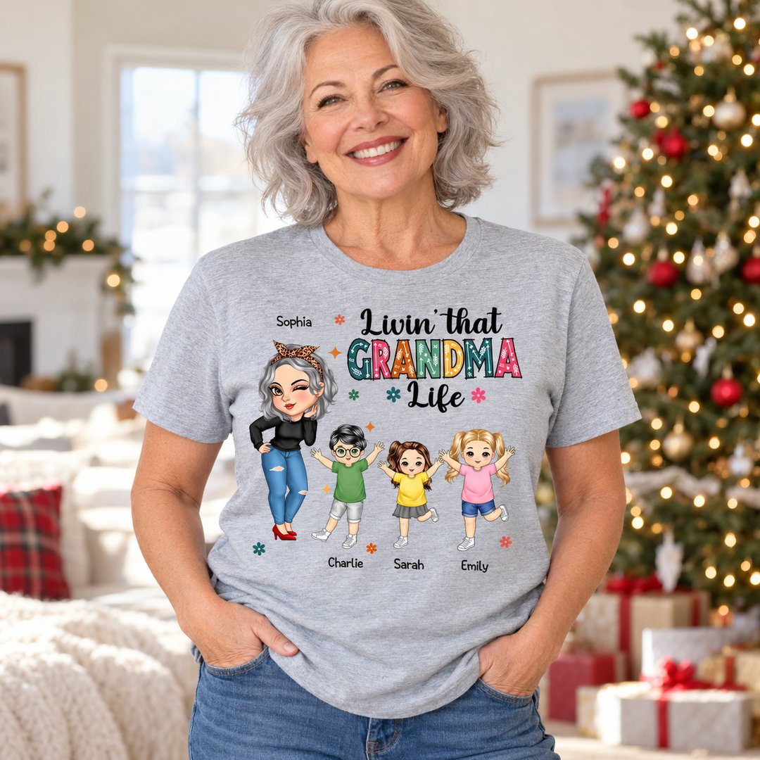 Grandma wearing personalized Livin That Grandma Life grey t-shirt in a bright holiday living room