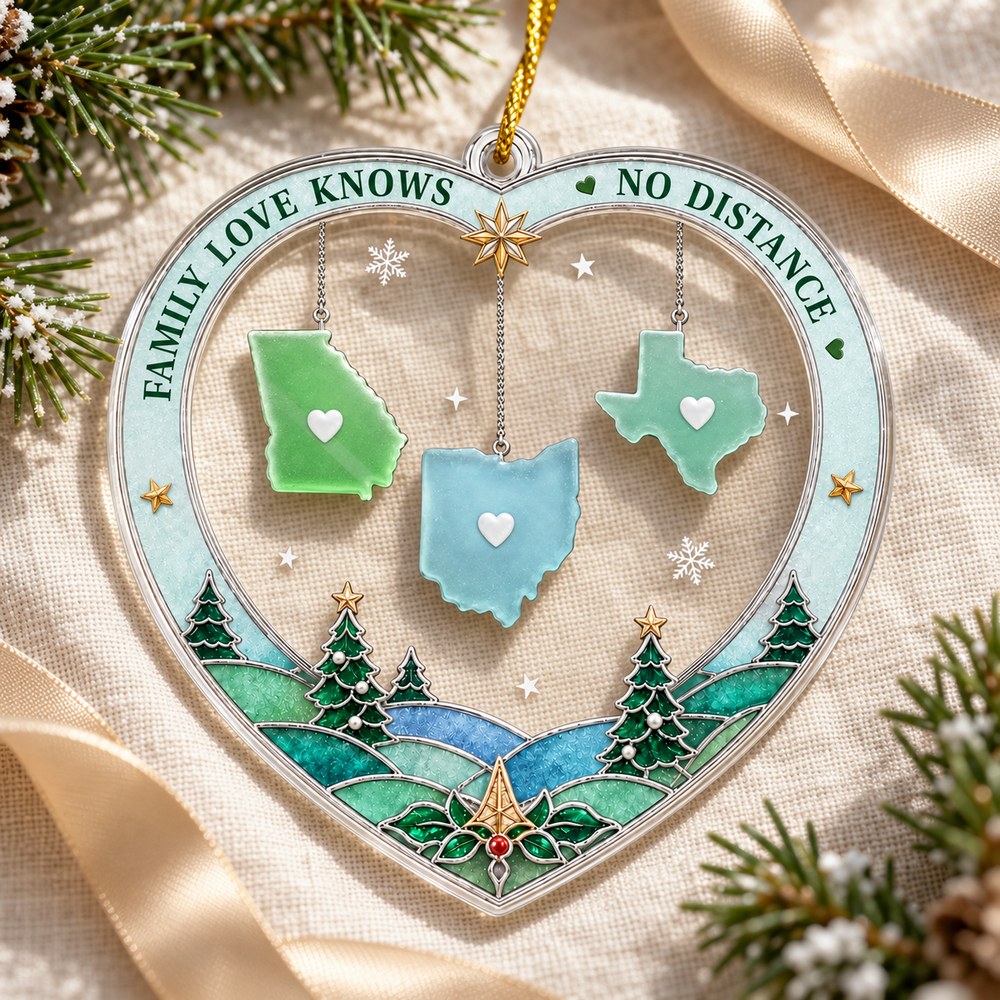 Long distance family heart acrylic ornament lying flat on cream linen with soft pine branches