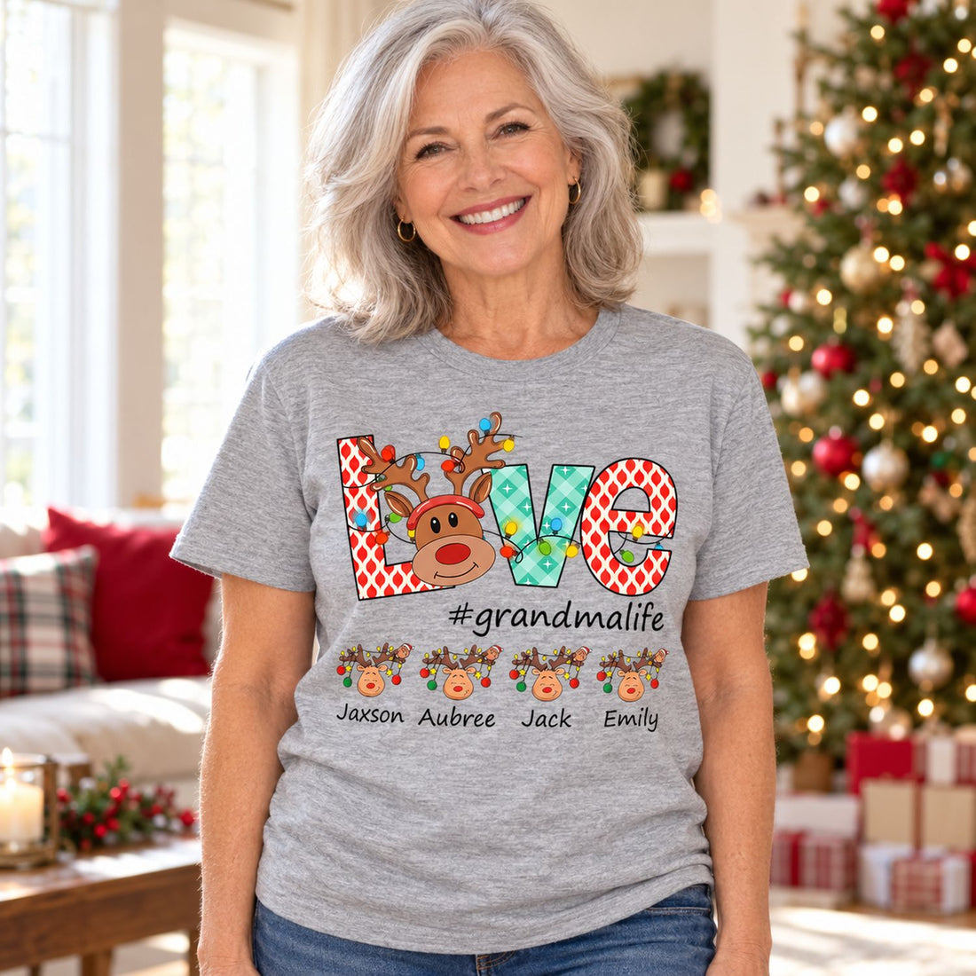 Grandma wearing personalized Love Little Reindeers grey Christmas t-shirt in a festive living room