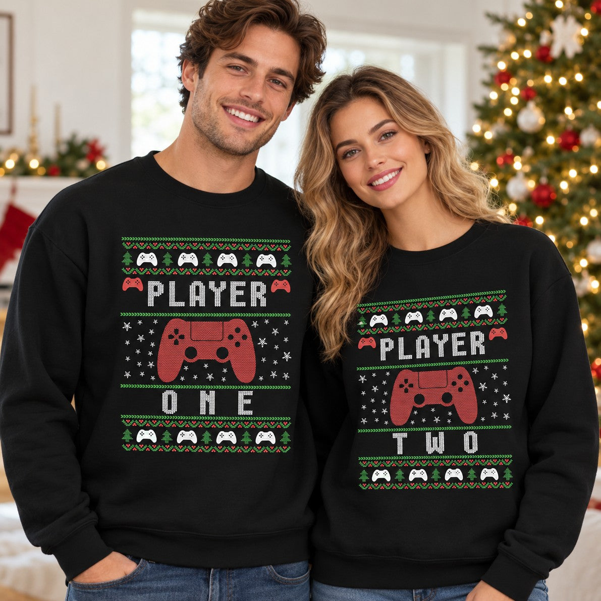 Couple wearing matching black Player One and Player Two Christmas sweatshirts in front of a holiday tree