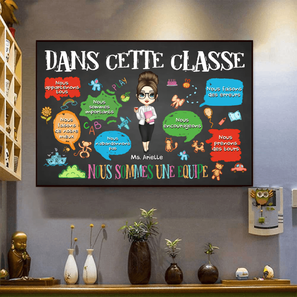 Personalized [French Version] In This Classroom We Are A Team poster, a woman hanging the framed print on a wall