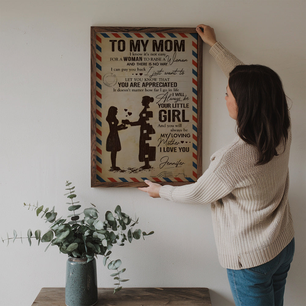 Personalized To My Beloved Mom & Dad poster, a woman hanging the framed print on a wall