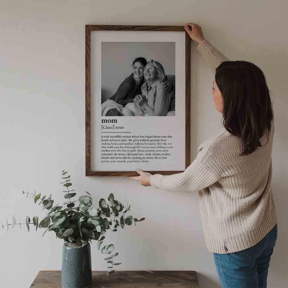 Custom Photo Mom Definition poster, a woman hanging the framed print on a wall