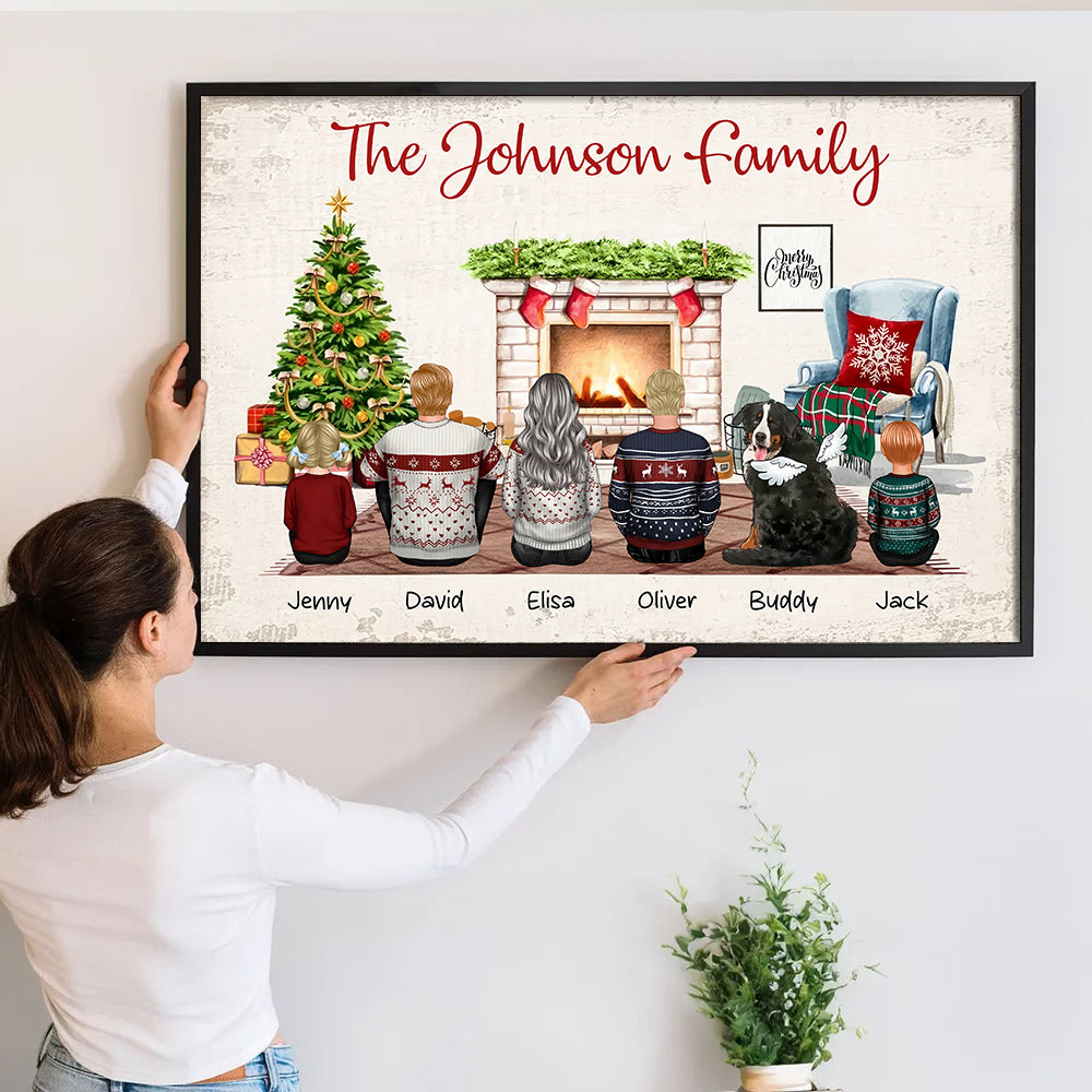 Personalized Christmas Family Back View Sitting Together poster, a woman hanging the framed print on a wall