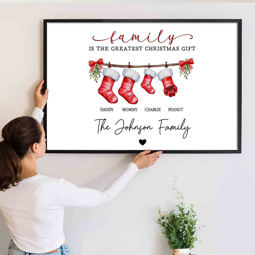 Personalized Family Is The Greatest Christmas Gift canvas print, a woman hanging the framed print on a wall
