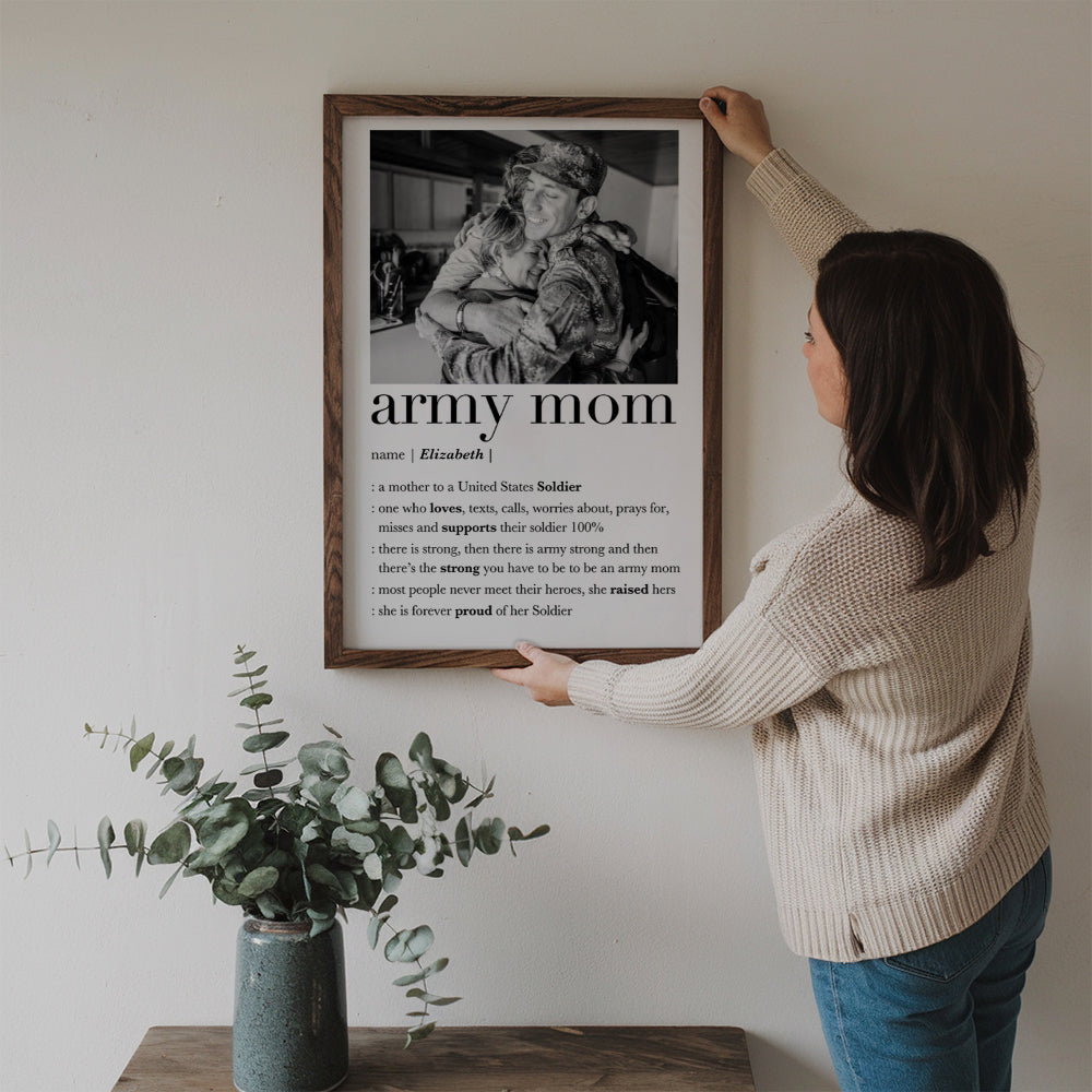 Custom Photo Army Mom poster, a woman hanging the framed print on a wall