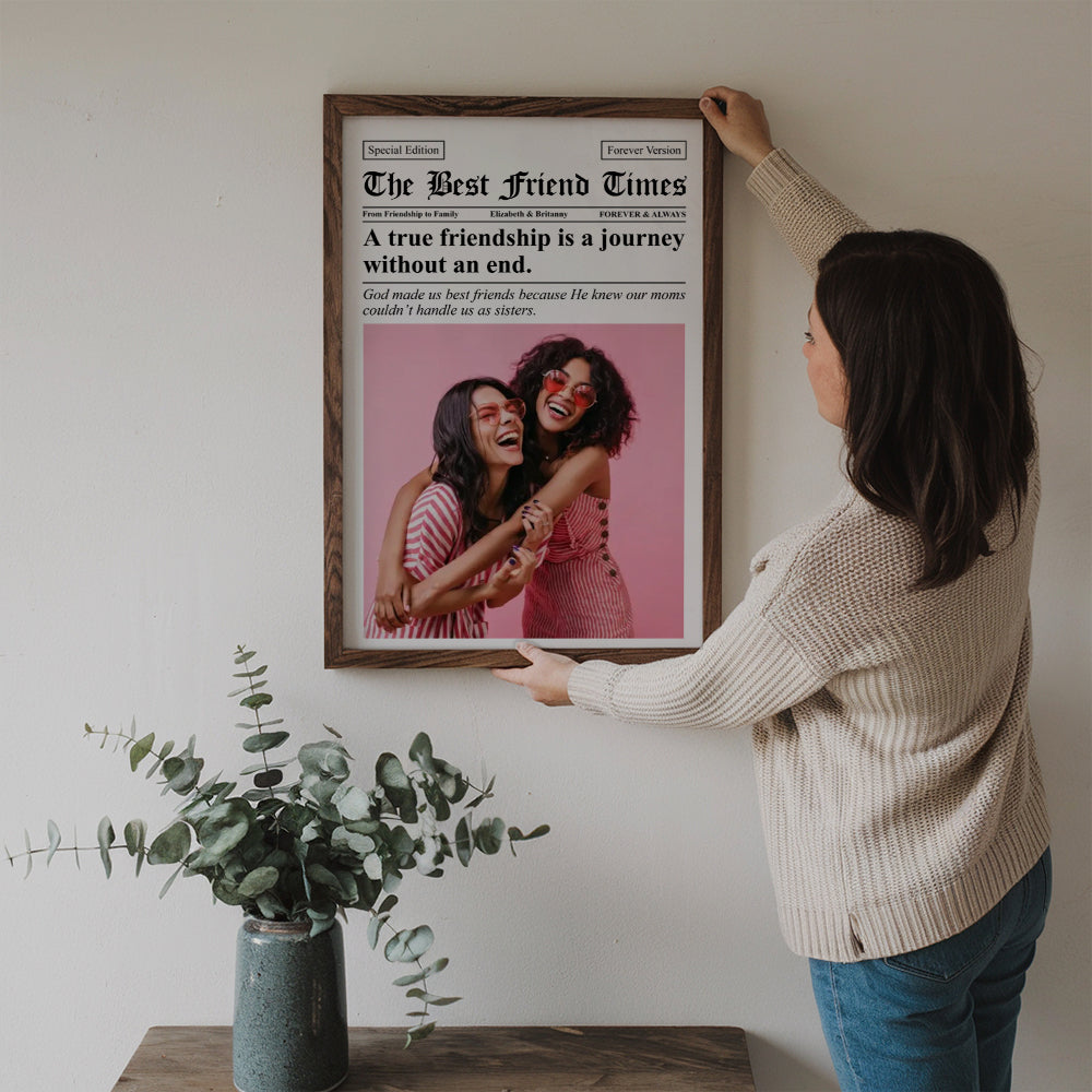 Custom Photo Newspaper The BFF Times poster, a woman hanging the framed print on a wall