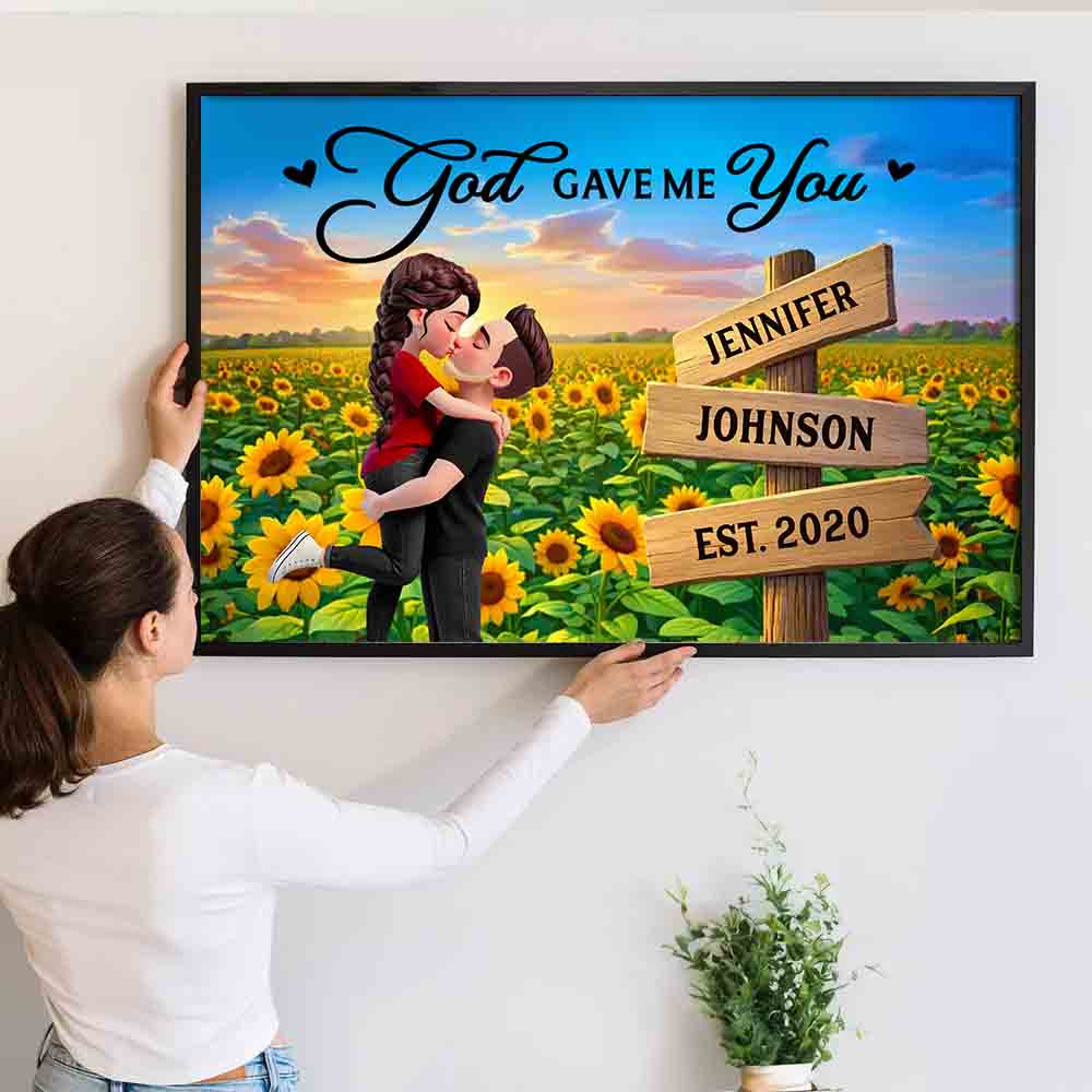 Personalized Couple Hugging Kissing Sunflower Field poster, a woman hanging the framed print on a wall