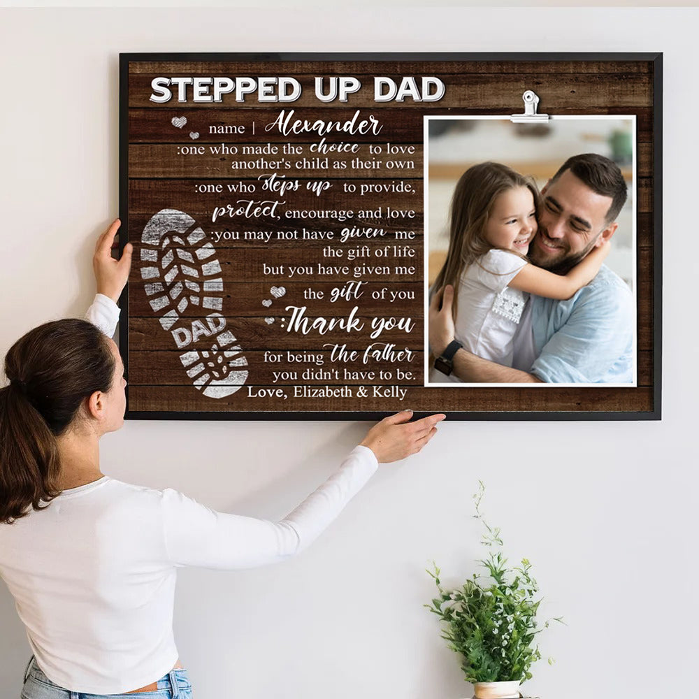 Custom Photo Stepped Up Dad poster, a woman hanging the framed print on a wall