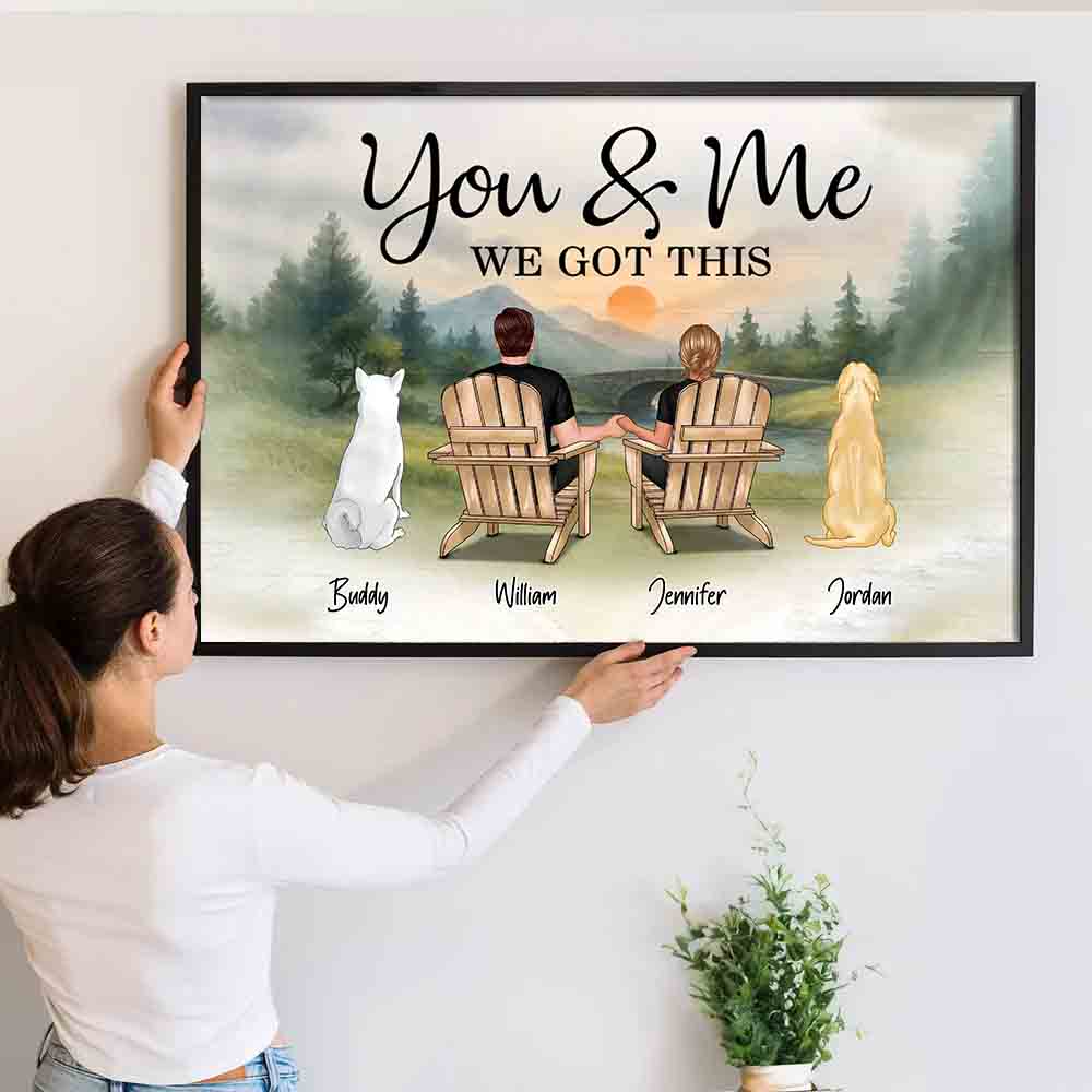 Personalized You & Me and the Dogs Couple canvas print, a woman hanging the framed print on a wall