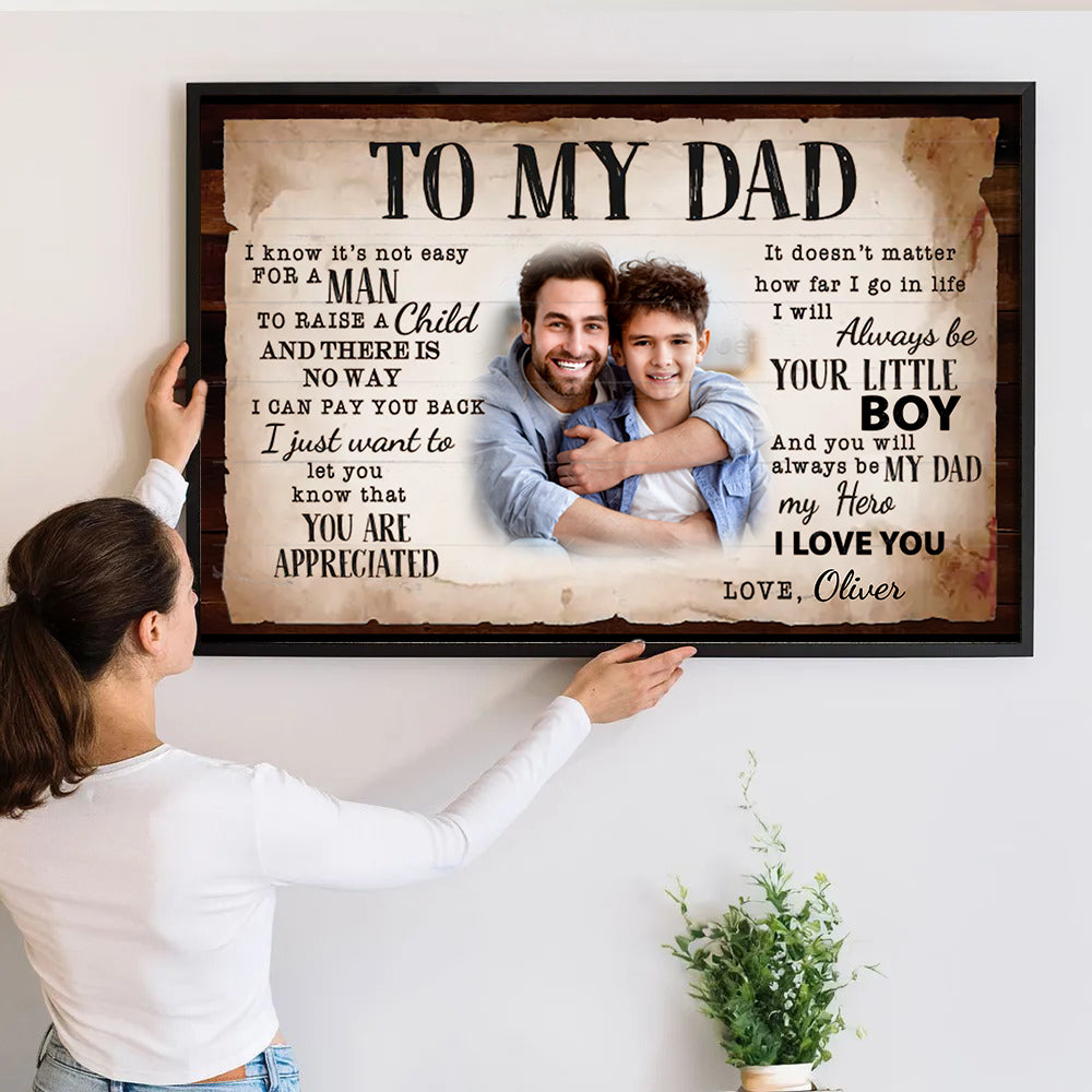 Custom Photo To My Dad poster, a woman hanging the framed print on a wall