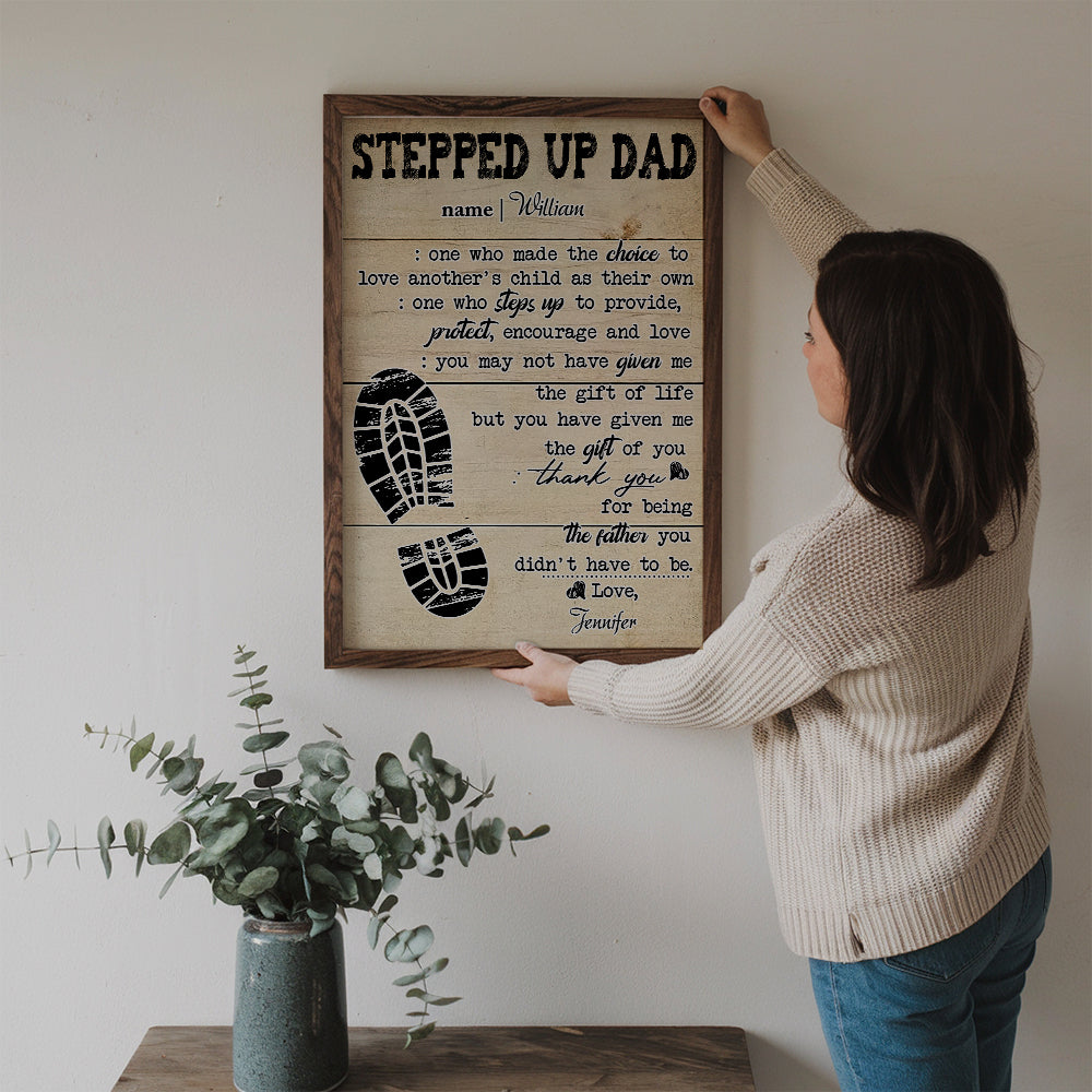 Personalized Stepped Up Dad Happy Father's Day canvas print, a woman hanging the framed print on a wall