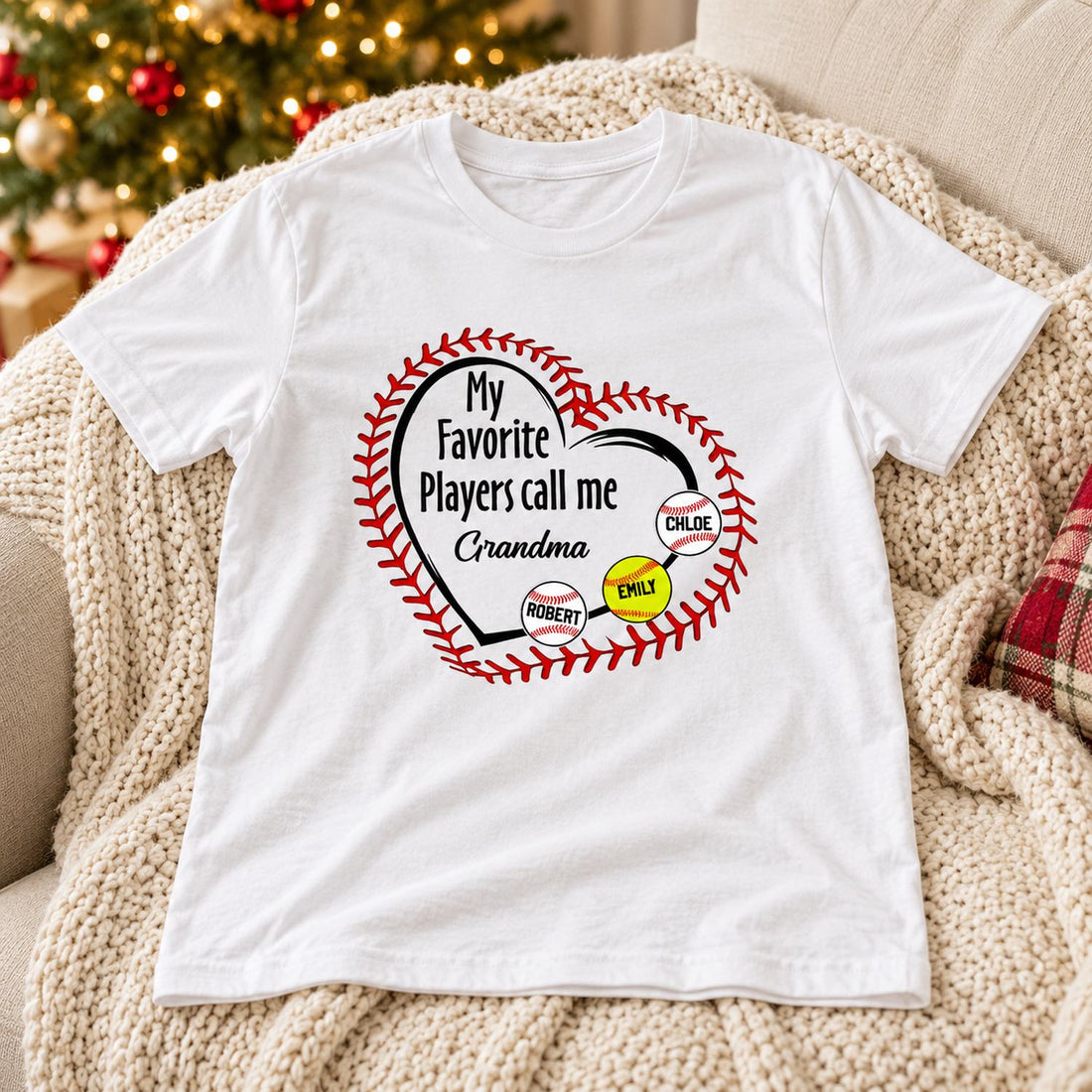 Personalized baseball grandma white t-shirt laid on a cozy sofa near Christmas tree