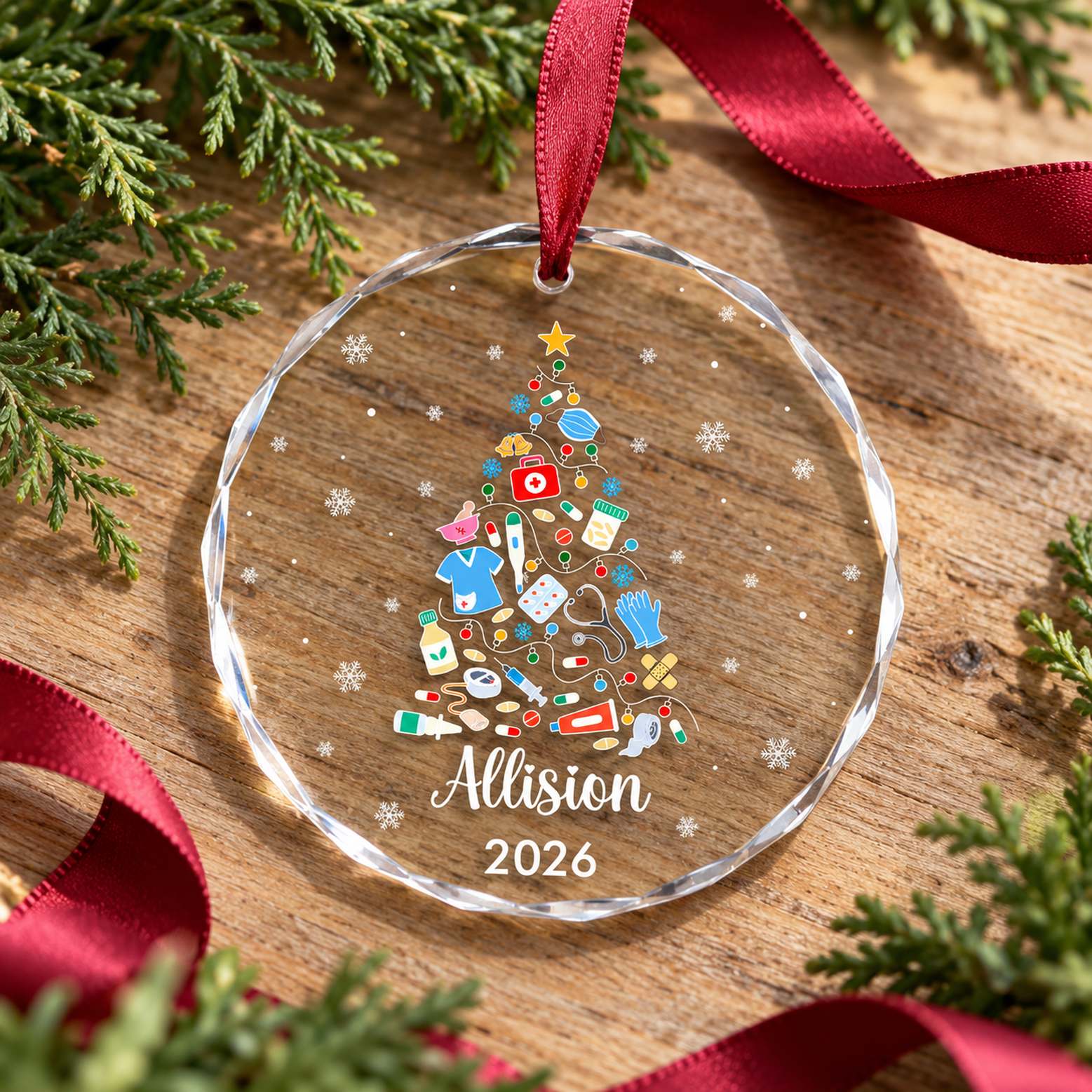 Nurse medical tree glass ornament lying flat on a light wood surface with cedar greenery