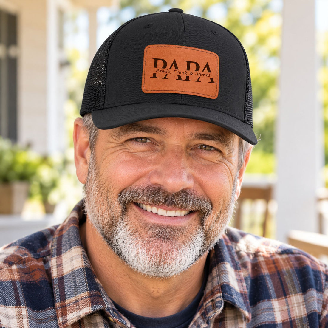 Papa wearing custom kids name leather patch trucker hat outdoors on a sunny porch