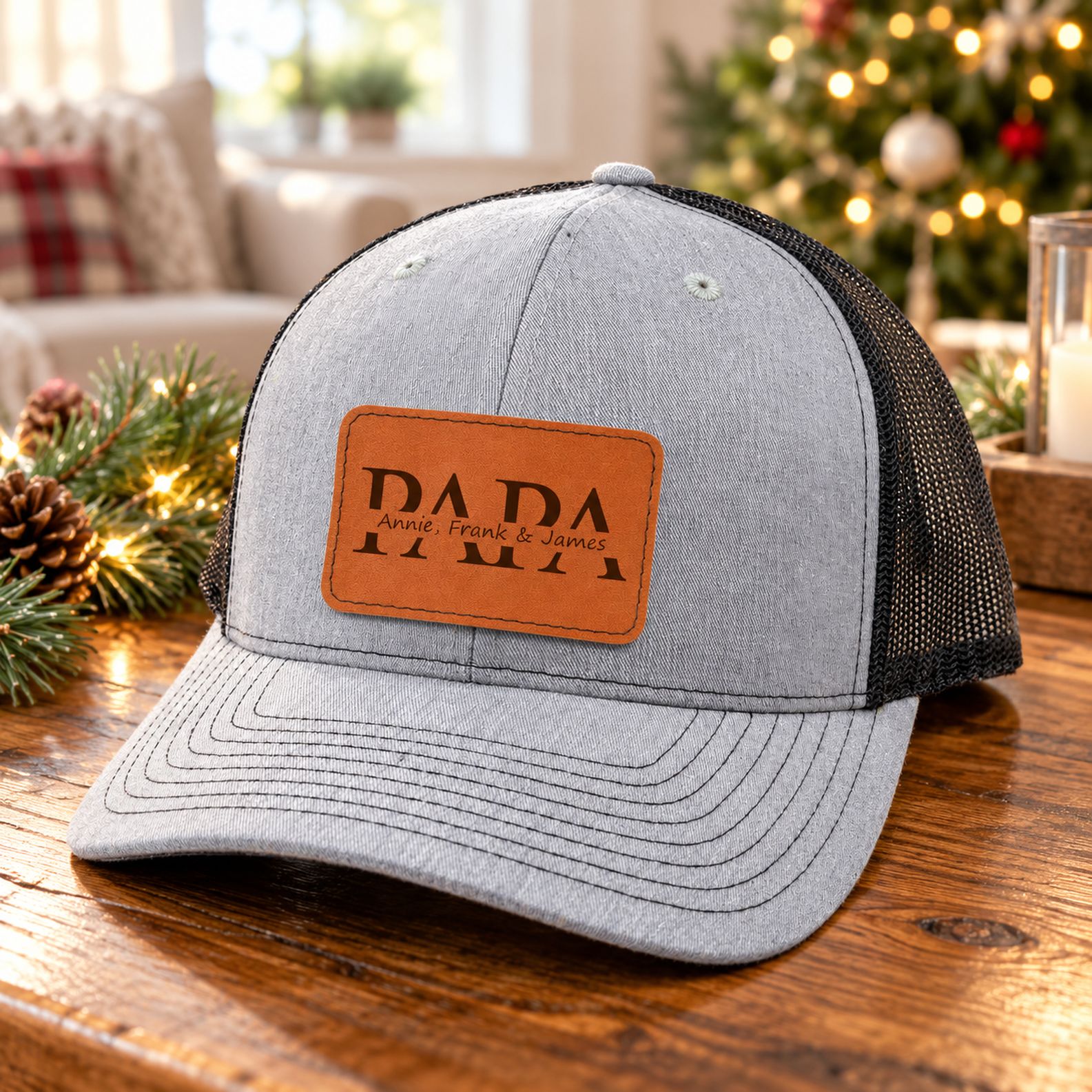 Custom Papa leather patch trucker hat on wooden table with holiday pine decor