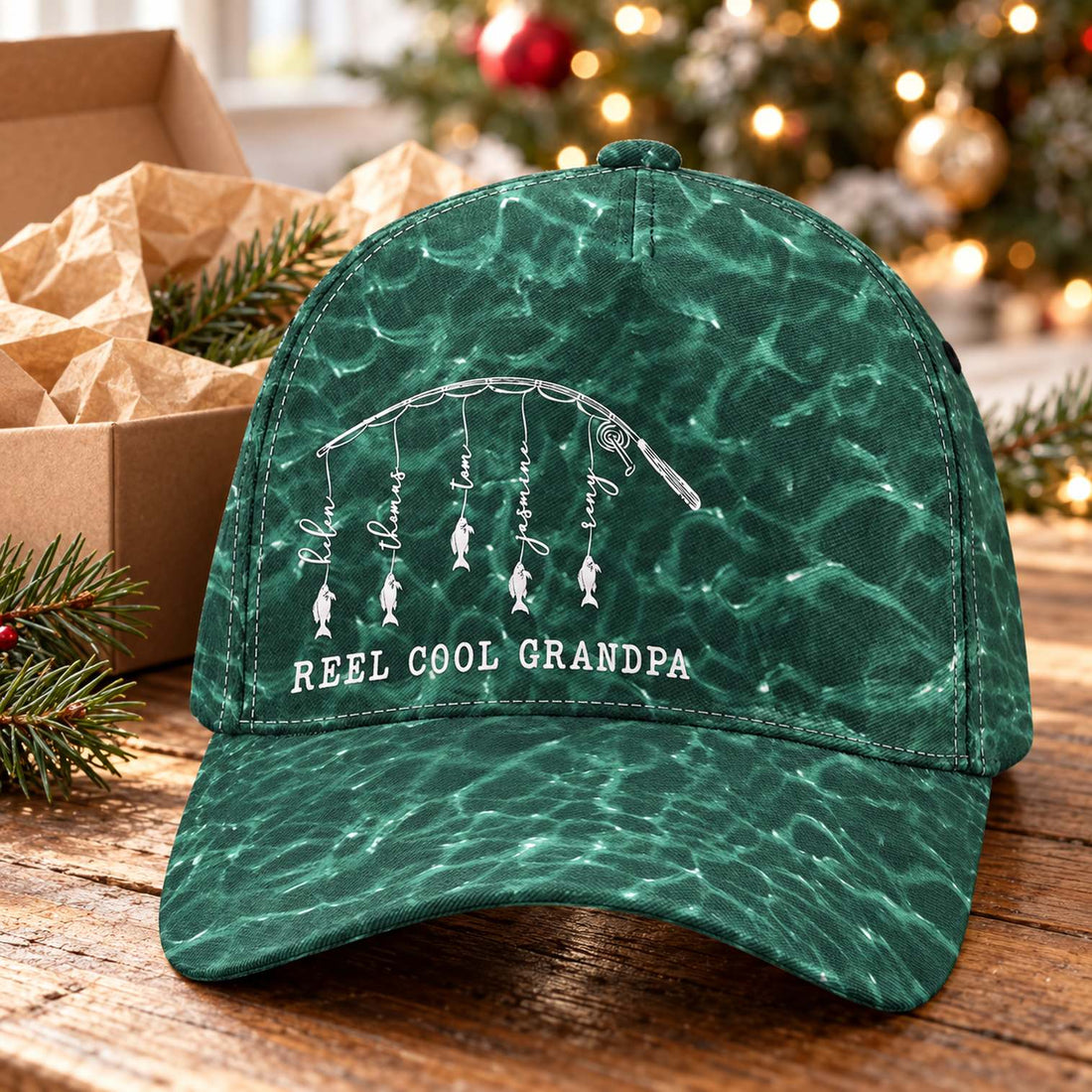 Reel Cool Grandpa fishing classic cap next to holiday gift box and pine