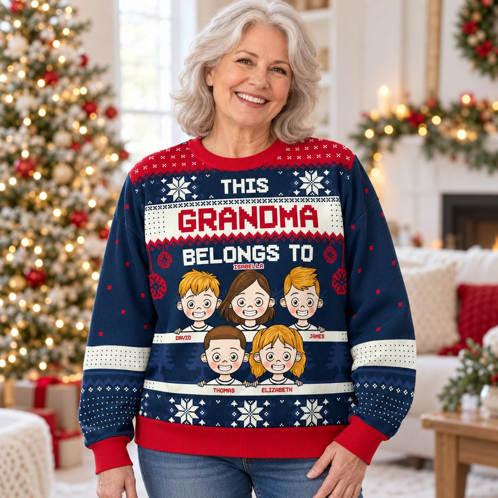 Grandma wearing personalized This Grandma Belongs To ugly Christmas sweater in festive living room