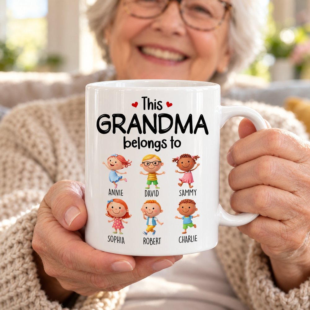 Grandma holding personalized This Grandma Belongs To ceramic mug with grandkids names in bright living room