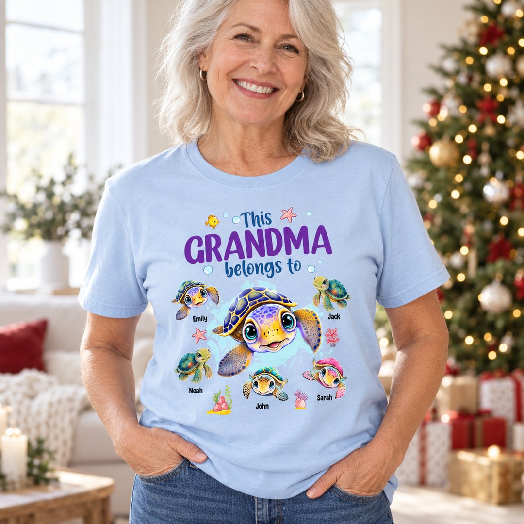 Grandma wearing light blue personalized This Grandma Belongs To sea turtles t-shirt in bright living room
