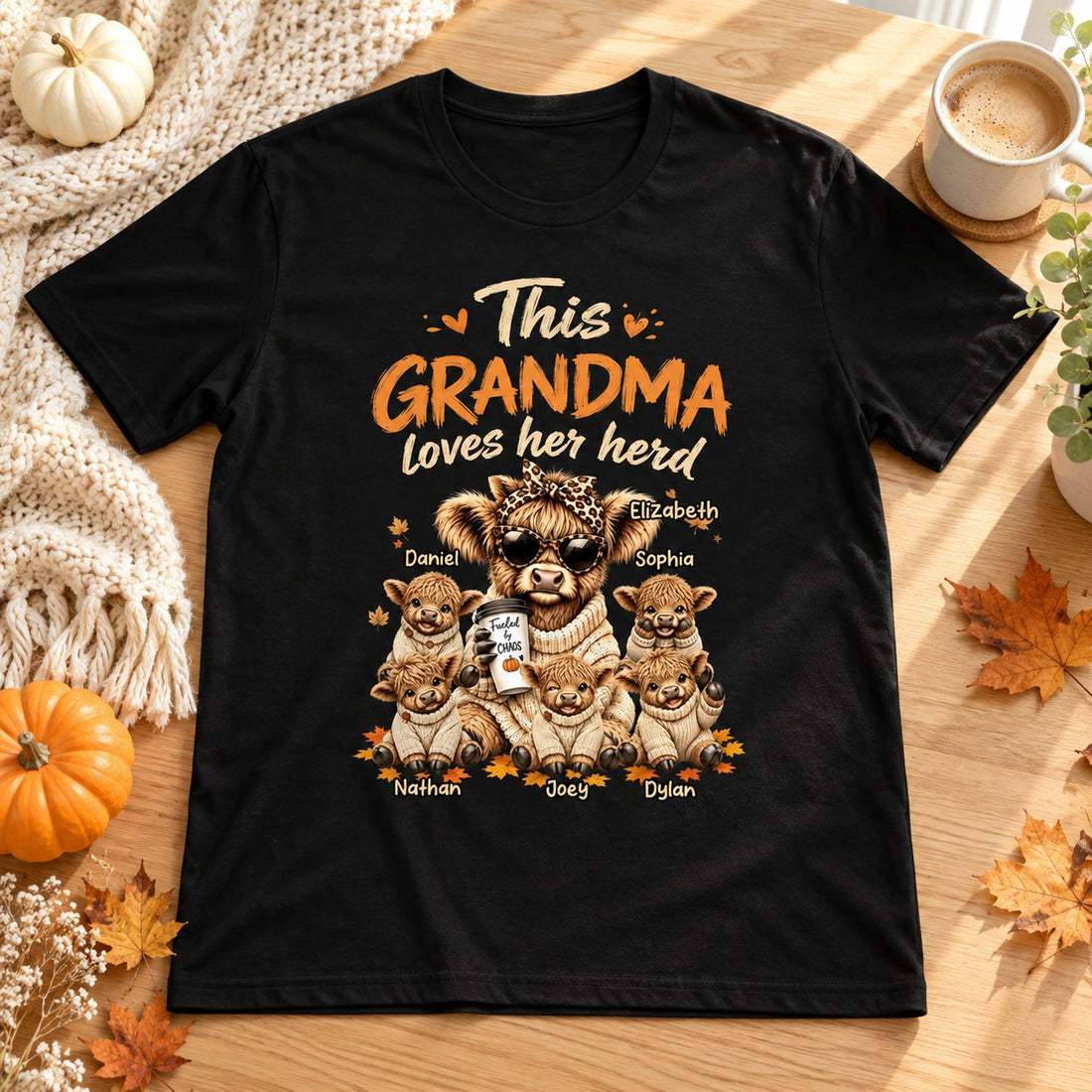 Personalized Grandma Loves Her Herd t-shirt flat lay with autumn pumpkins and cozy knit throw