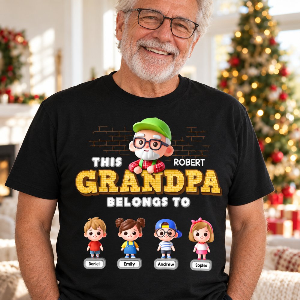 Grandpa wearing This Grandpa Belongs To personalized black t-shirt in a bright holiday living room
