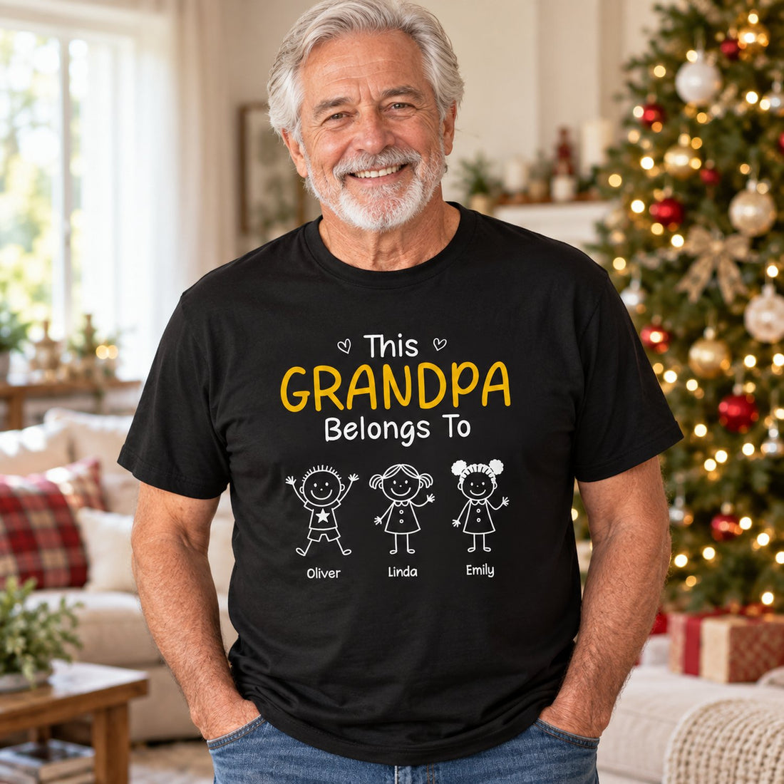 Grandpa wearing personalized This Grandpa Belongs To black t-shirt in a bright holiday living room