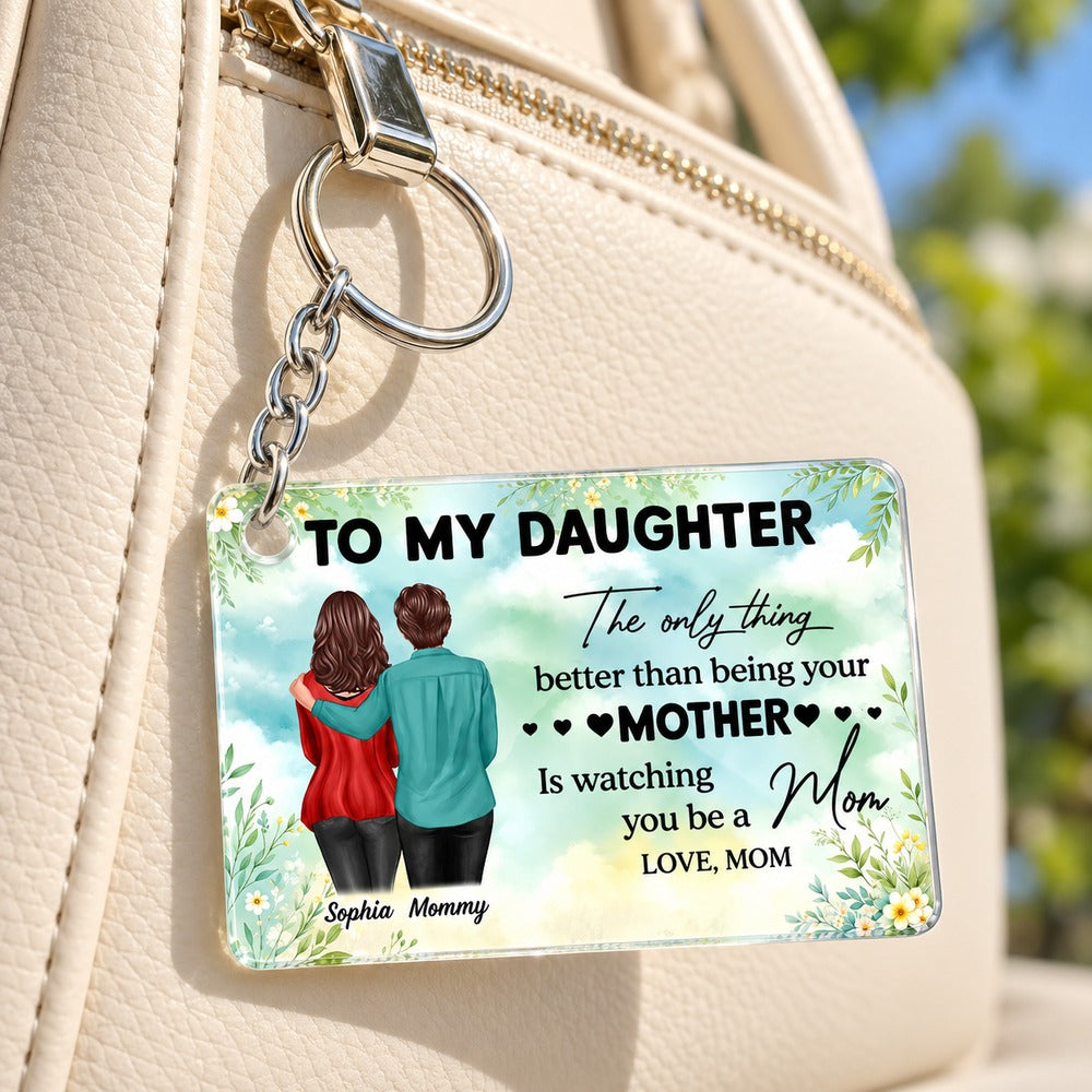 Personalized To My Daughter acrylic keychain hanging from a cream leather handbag zipper