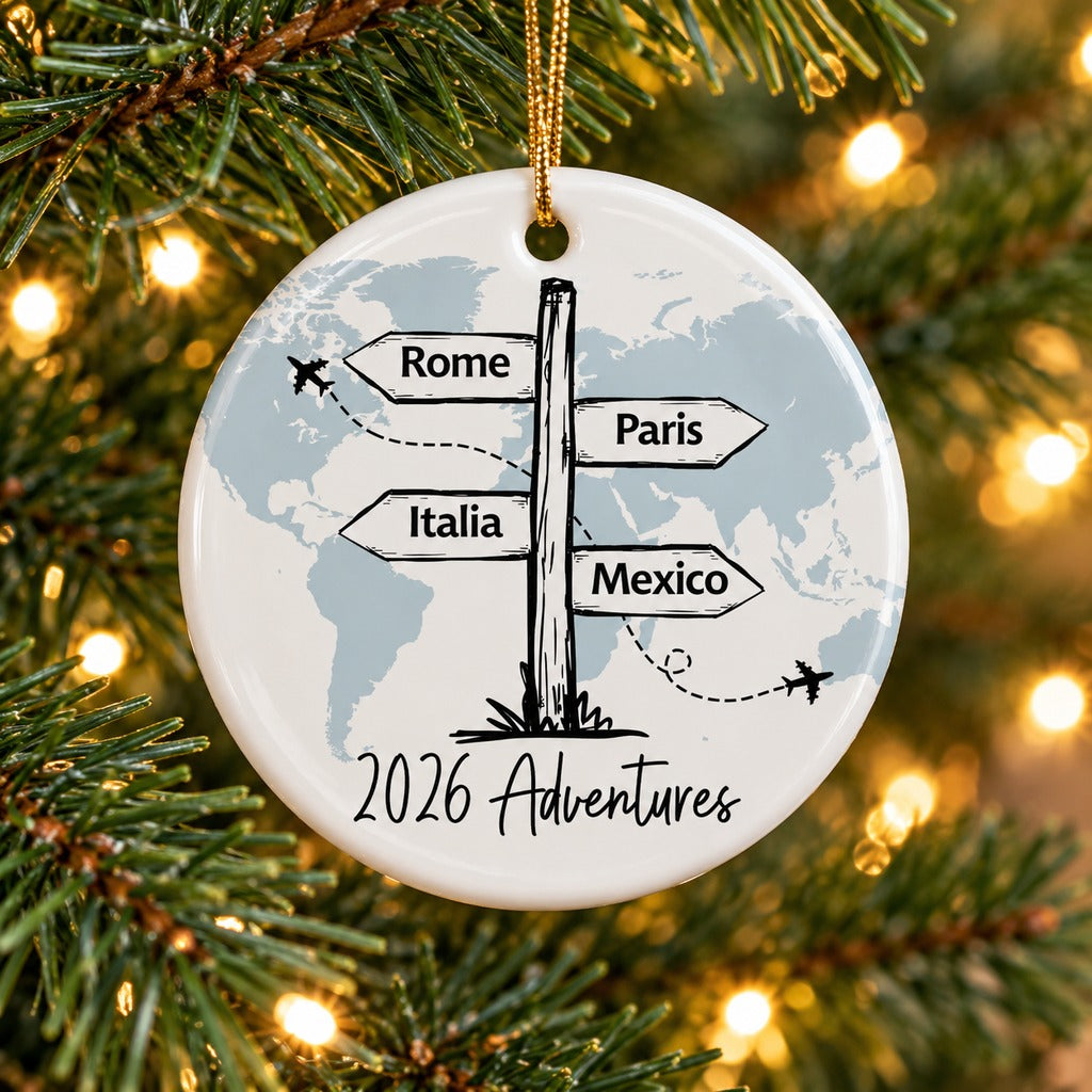 Personalized travel ceramic ornament hanging on a Christmas tree branch with warm holiday lights