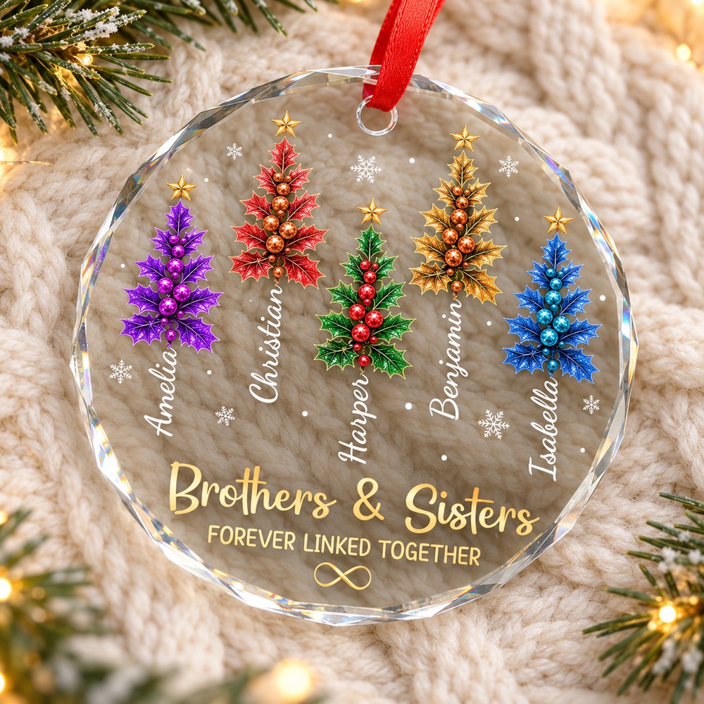 Brothers and sisters personalized circle glass ornament lying flat on a cozy cream knit blanket with pine sprigs