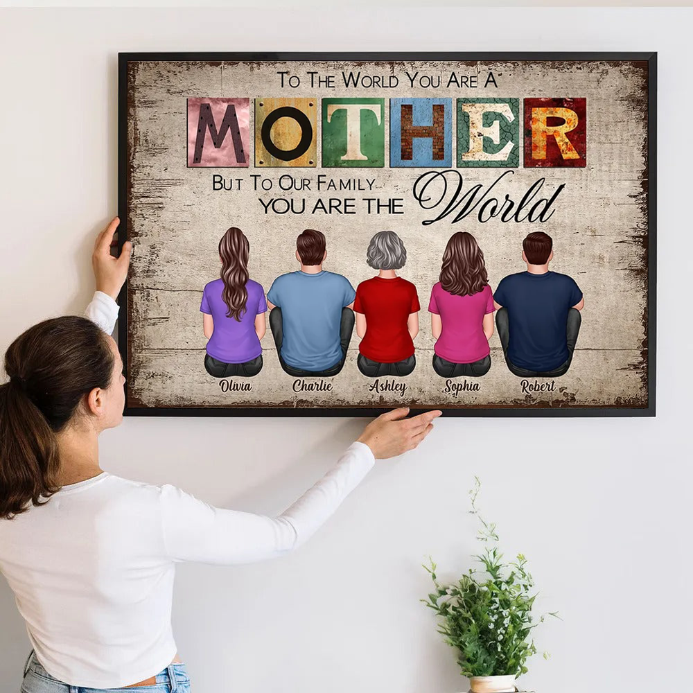 Personalized To The World You Are A Mother poster, a woman hanging the framed print on a wall