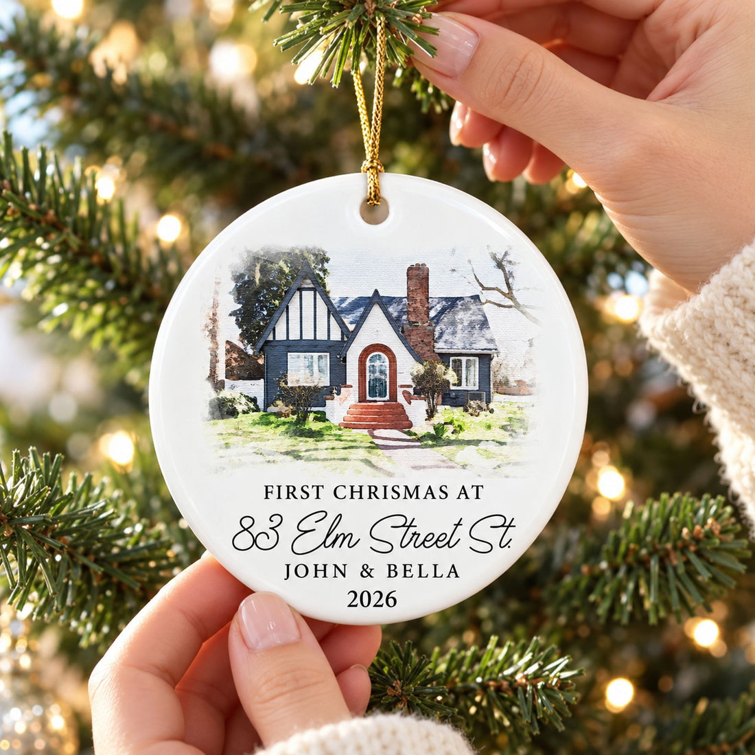 Personalized circle ceramic new home ornament being hung on a Christmas tree branch