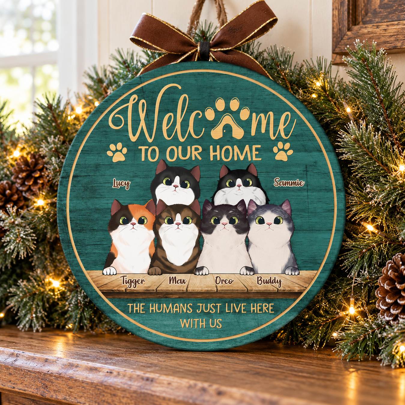 Welcome To Our Home cat wood sign displayed with Christmas pine garland