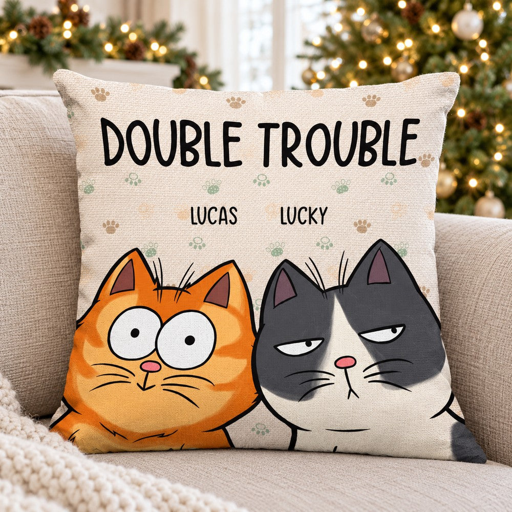 Personalized Double Trouble cat throw pillow on a cozy sofa with Christmas tree lights in background