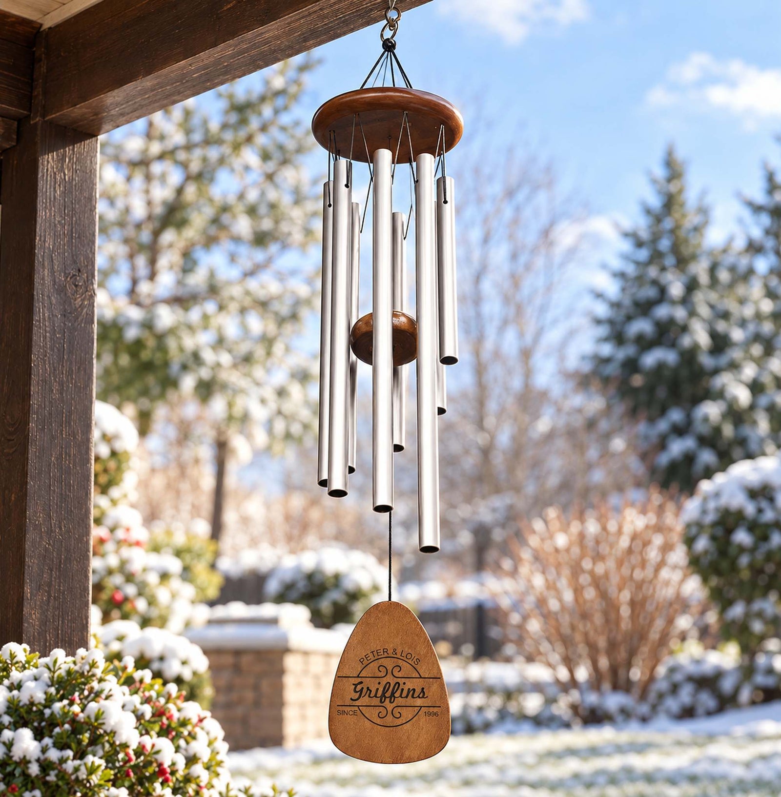 Custom engraved silver wind chime for couples hanging from a wooden porch beam outdoors