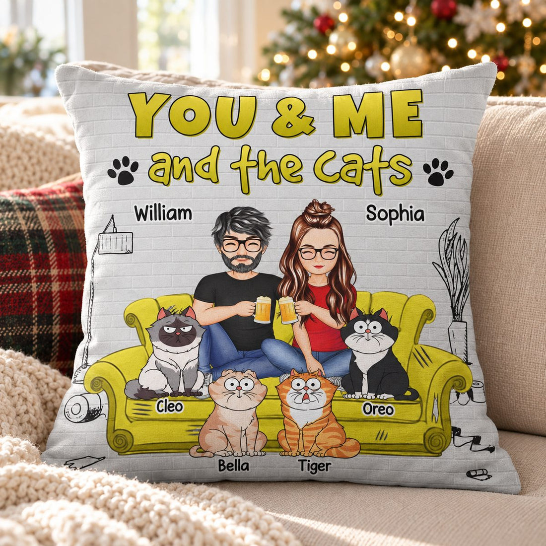 You And Me And The Cats custom pillow on a cozy sofa with a Christmas tree in the background
