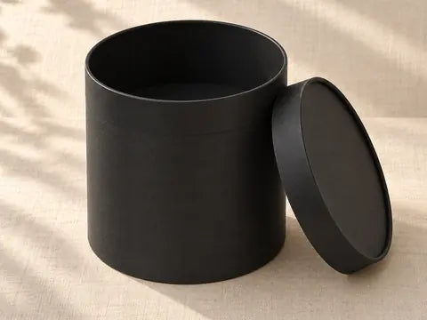 Round black gift box with the lid lifted off